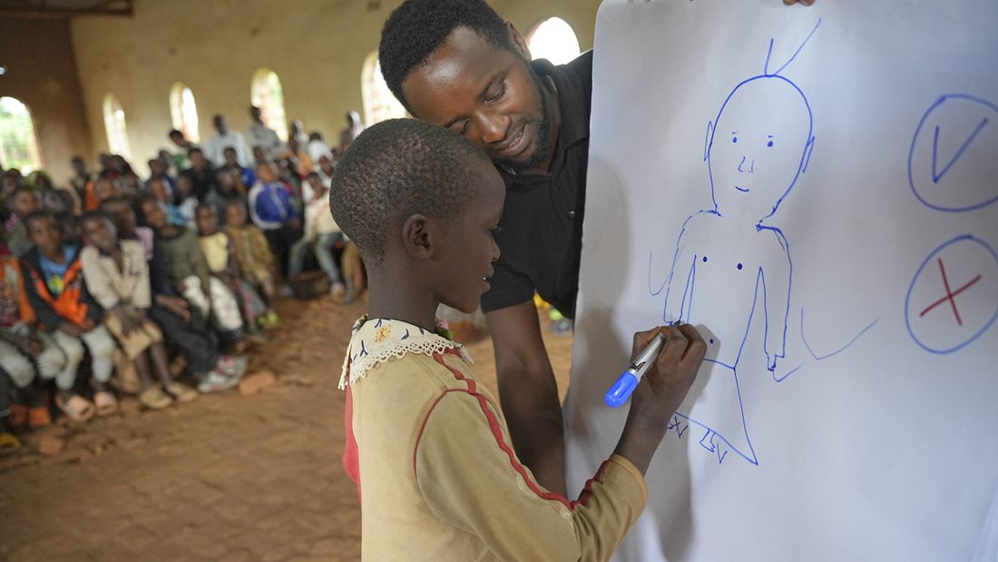A thinkSMALL teacher drawing with a child at an outreach