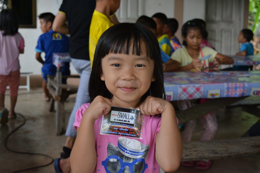 A girl holding her thinkSMALL Cinema card